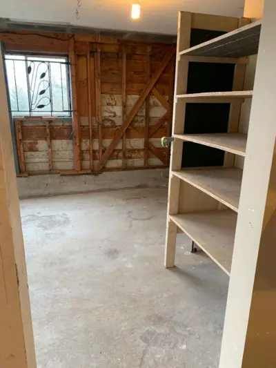 A picture of a very clean garage. There is nothing on the floor and no junk on the walls or shelf.