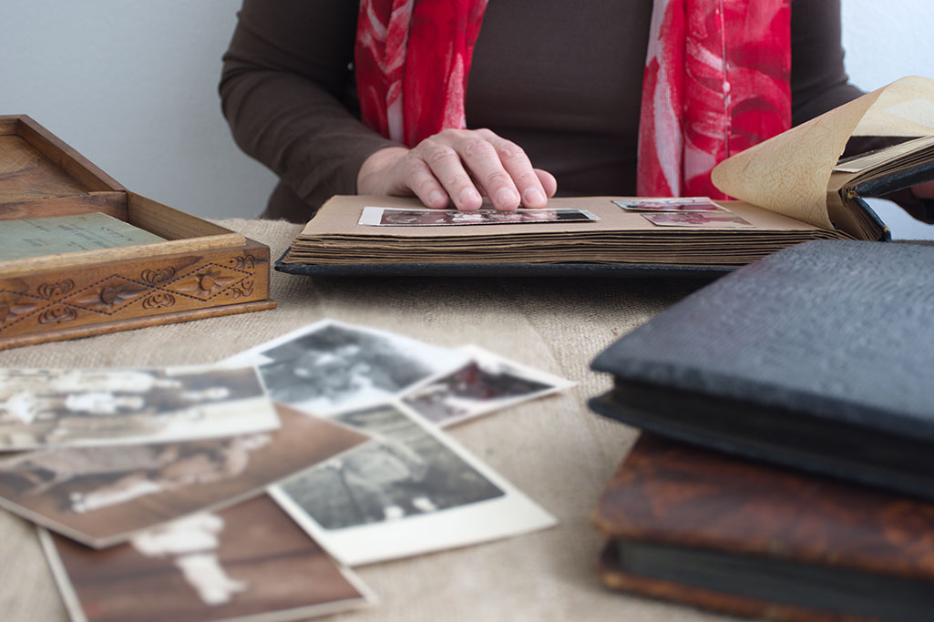 person-looking-through-old-photographs-and-memorie-web