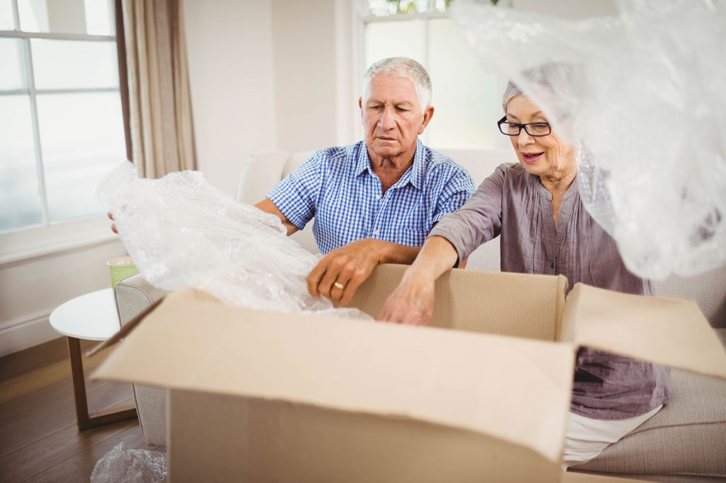 senior-couple-unpacking-belongings-after-moving-ho-web